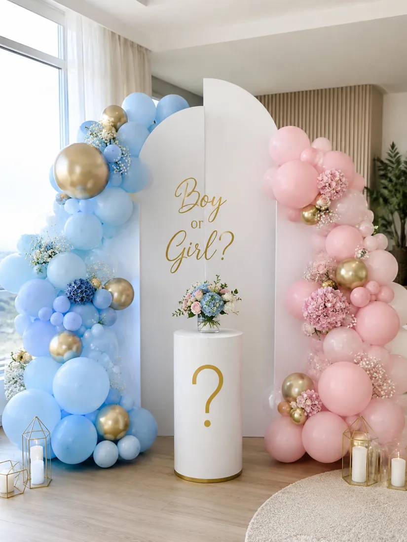 Şık salonda solda mavi-gold, sağda pembe-gold balon kemerleri; ortadaki beyaz kemerli backdrop'ta gold "Boy or Girl?" yazısı ve soru işaretli beyaz sütun — cinsiyet belirleme partisi balon süslemesi, Esin Balon İstanbul